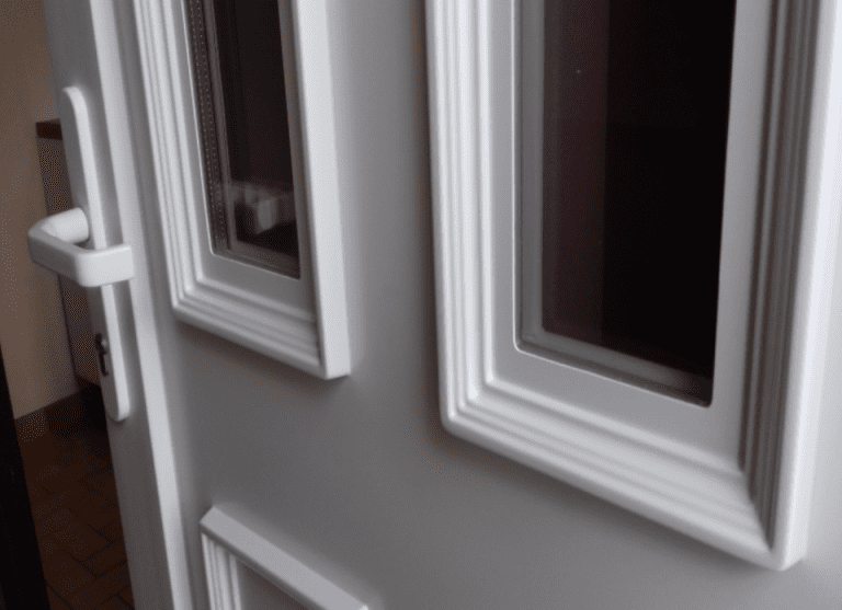 Détail de moulure sur une porte d'entrée PVC blanc vitrée