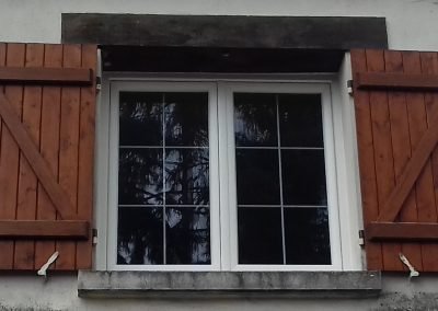 Fenêtre PVC avec croisillons en laiton et volets battants en bois