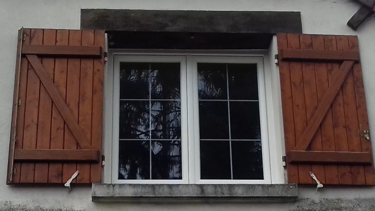 Fenêtre PVC avec croisillons en laiton et volets battants en bois