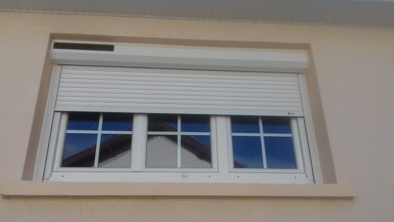 Volet roulant solaire blanc sur fenêtre trois vantaux